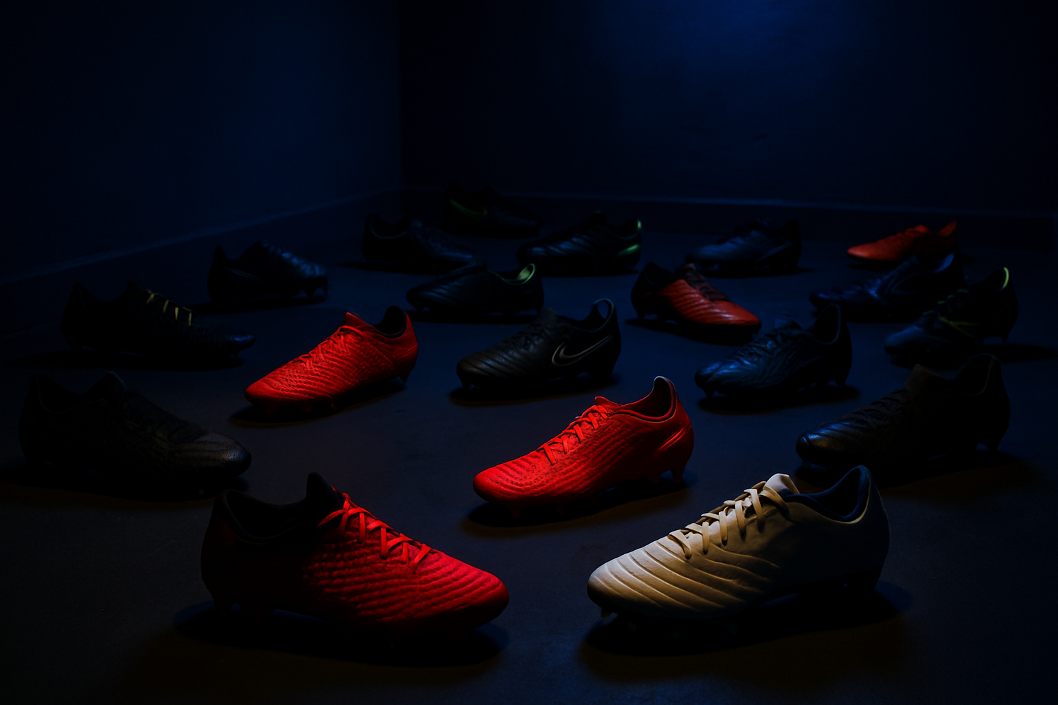 muchos zapatos de futbol regado pupos o pupillos en una sala oscura de color azul oscuro con iluminacion 